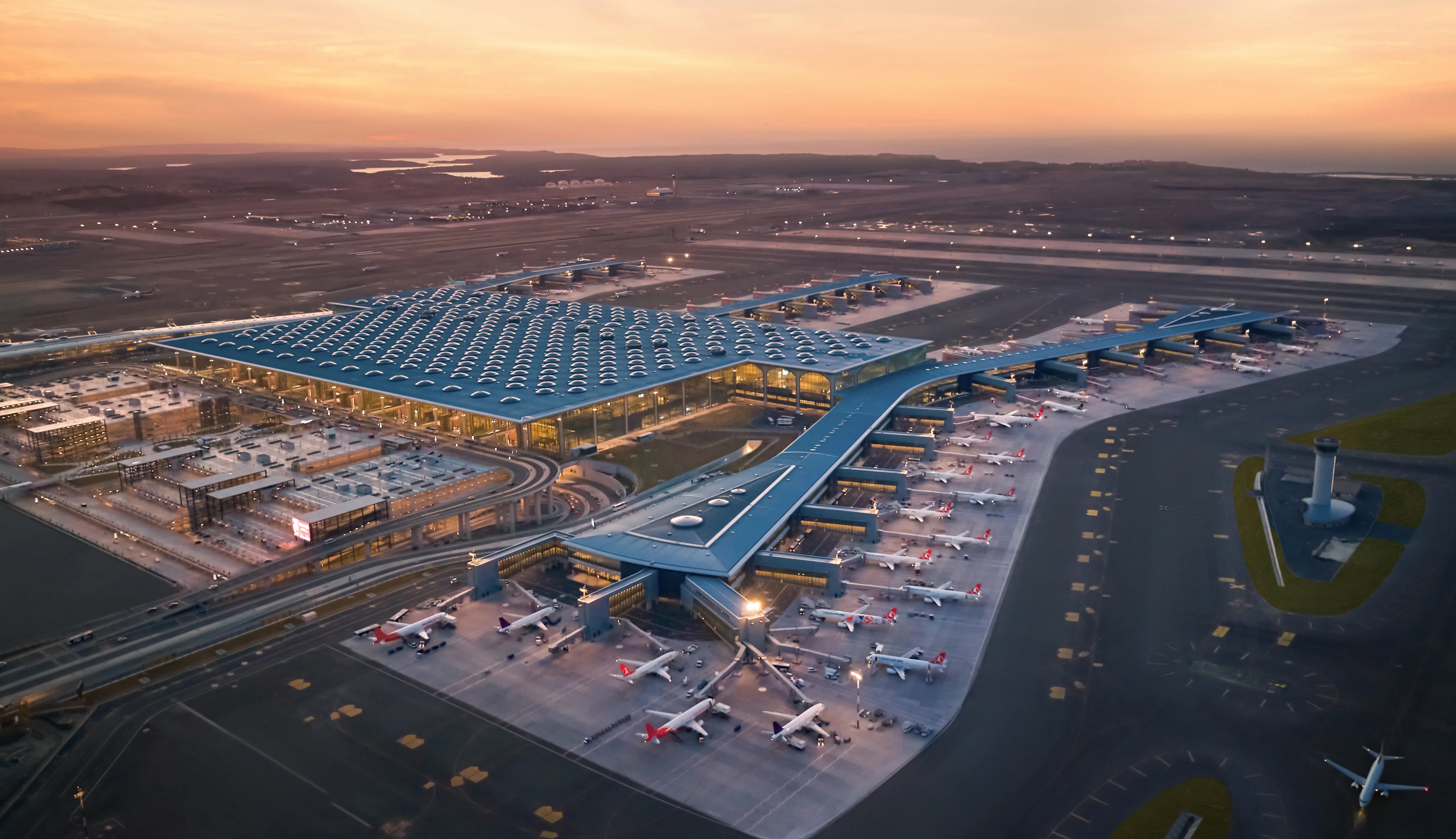 Aerial view of Istanbul Airport's terminal and control tower at sunset